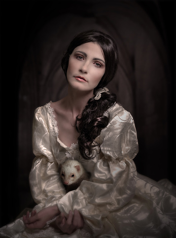 portrait of woman in vintage dress on dark background with texture of a painting of the Renaissance