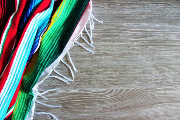 istock fiesta poncho background cinco de mayo serape wooden copy space background with stiped fringe blanket 673465152