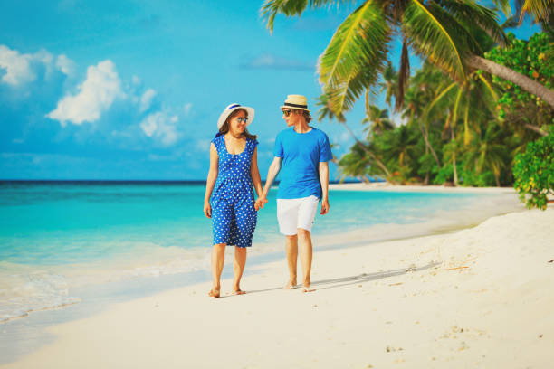istock happy loving couple walking on summer beach 673465494