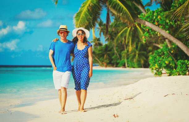 istock happy loving couple walking on summer beach 673467568