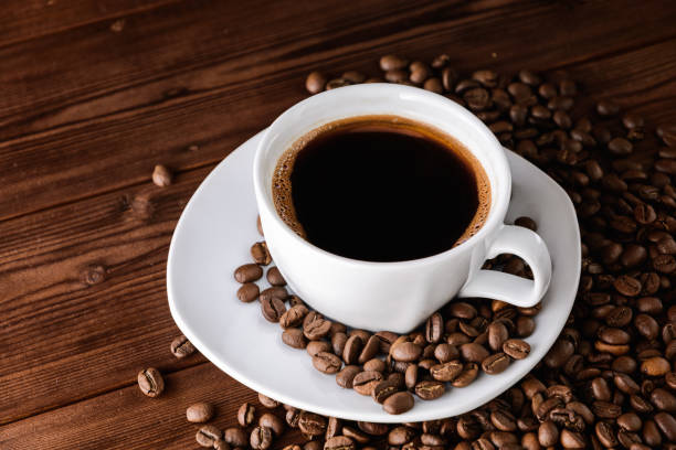 istock Coffee cup with saucer and beans on wooden table. 673468826
