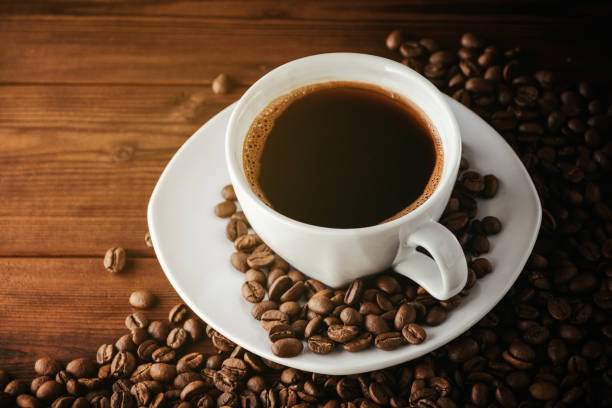 istock Coffee cup with saucer and beans on wooden table. 673468832