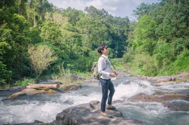 istock Businessman with backpack and laptop and phone at  waterfall  the forest. 673472652