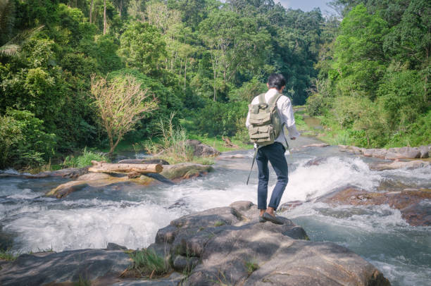 istock Hiker backpack with laptop and phone at  waterfall  the forest. 673473854