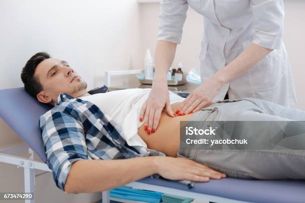 Handsome Nice Man Being Examined By The Doctor Stock Photo - Download Image Now - Stomachache, Doctor, Advice