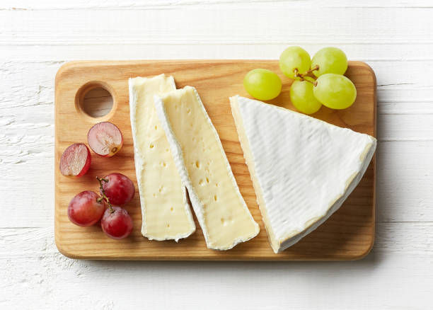 Piece of brie cheese Piece of brie cheese on cutting board. From top view brie stock pictures, royalty-free photos & images