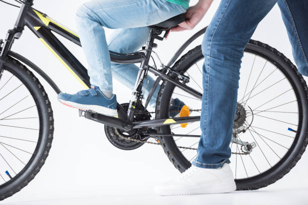 istock father helping son to ride bicycle 673492218