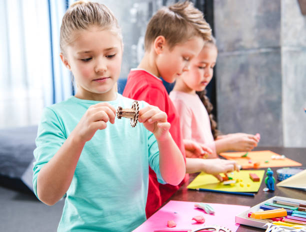 istock Kid holding wooden gear toy 673494134