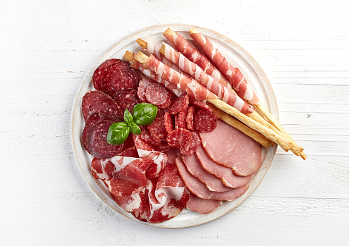 Cutting board with typical Tuscan appetizer. Pecorino cheese, salami, finocchiona, pods, ham.