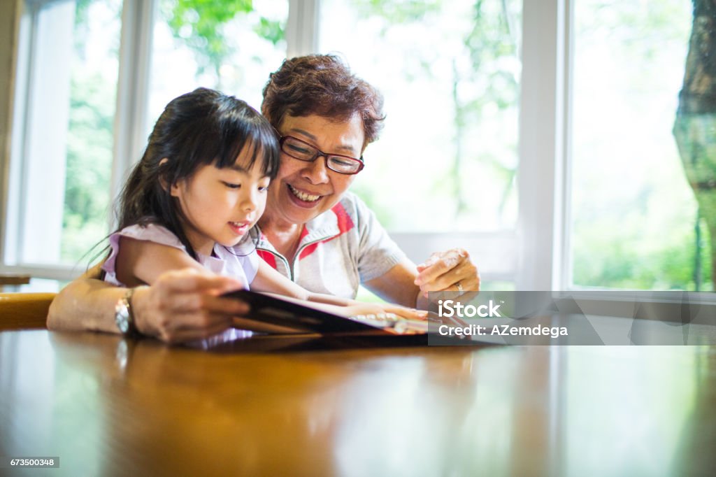 Learning Grandmother teaching her granddaughter Grandparent Stock Photo