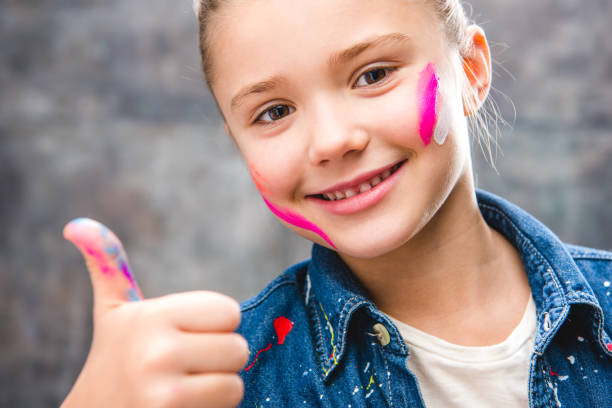 istock Schoolgirl artist with painted face 673502902