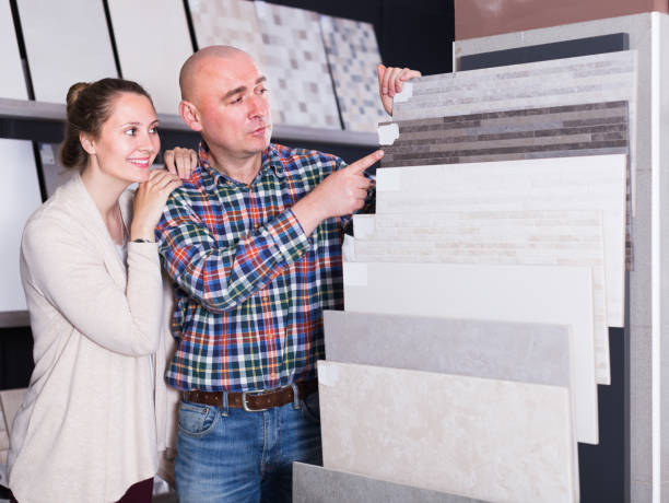 istock Young family couple looking at ceramic tile in store 673505520