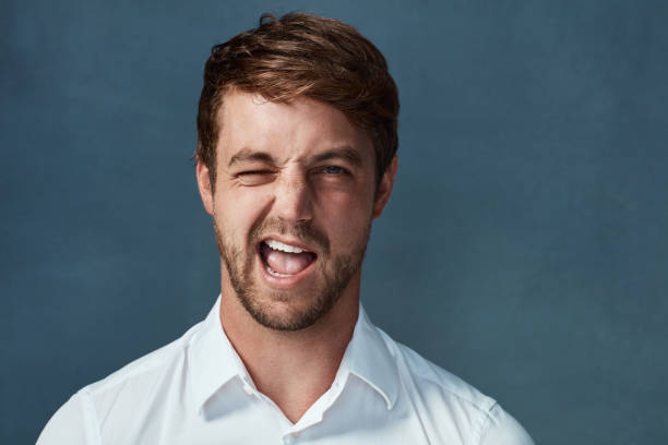 If you get what I'm saying... Studio portrait of a handsome young man winking against a dark background young man wink stock pictures, royalty-free photos & images