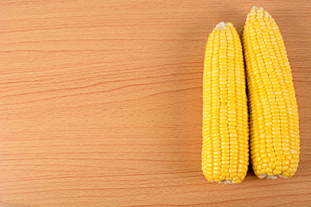 istock yellow corn on wooden background 673511852
