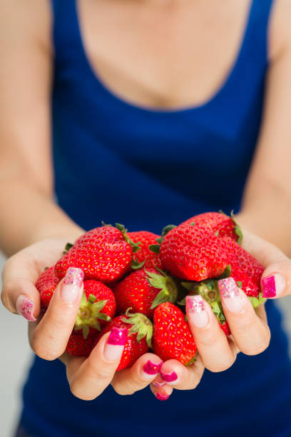 Fresh strawberries closeup. holding strawberry in hands