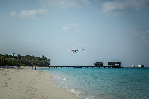 The takeoff of a seaplane from the ocean beach.