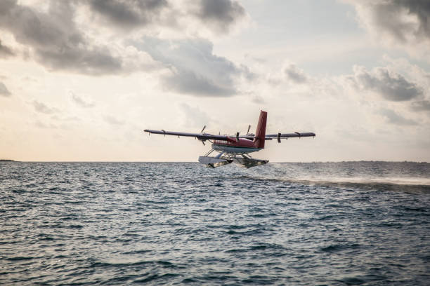 Seaplane taking off at sunset, in the ocean the lagoon of a tropical island