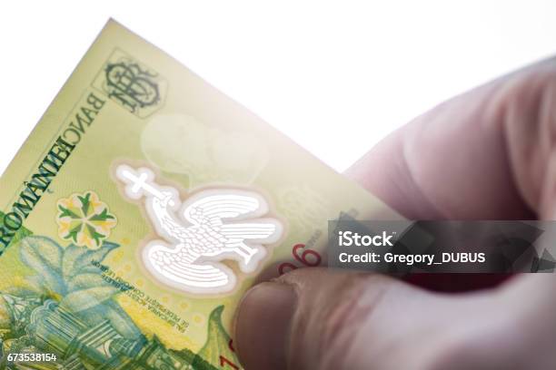 Romanian Leu Currency Closeup Hand Holding And Looking Through One Leu Bank Note Stock Photo - Download Image Now