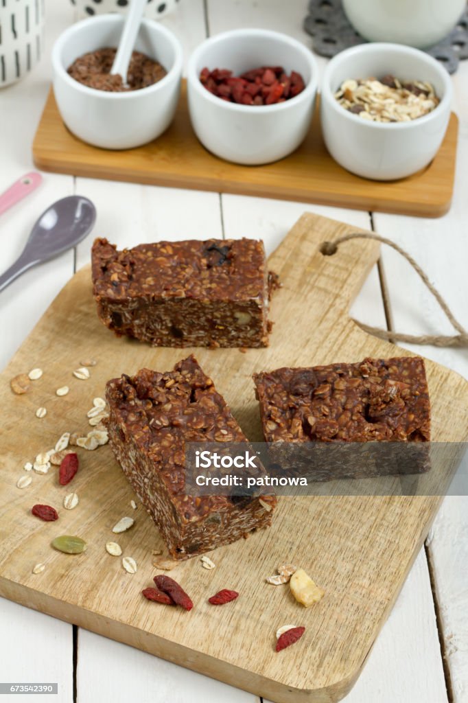 Energy bars with oat, Goji berries, sesame, chocolate and honey. Energy bars with oat, Goji berries, sesame, chocolate and honey. White background, white pottery. Almond Stock Photo