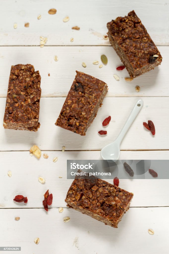Energy bars with oat, Goji berries, sesame, chocolate and honey. Energy bars with oat, Goji berries, sesame, chocolate and honey. White background, white pottery. Almond Stock Photo