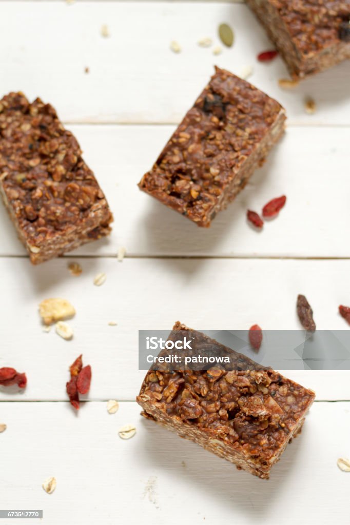 Energy bars with oat, Goji berries, sesame, chocolate and honey. Energy bars with oat, Goji berries, sesame, chocolate and honey. White background, white pottery. Date - Fruit Stock Photo