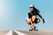 Beautiful skater woman riding on her longboard.