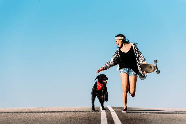 istock Beautiful young skater playing with her dog. 673559206
