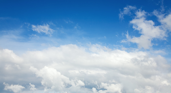 White fluffy clouds in the blue azure sky panorama. Summer good weather background.