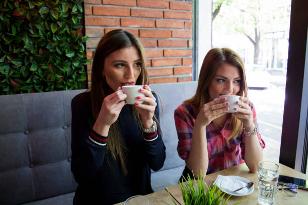 istock Two girls drinking coffee in coffee house 673571090