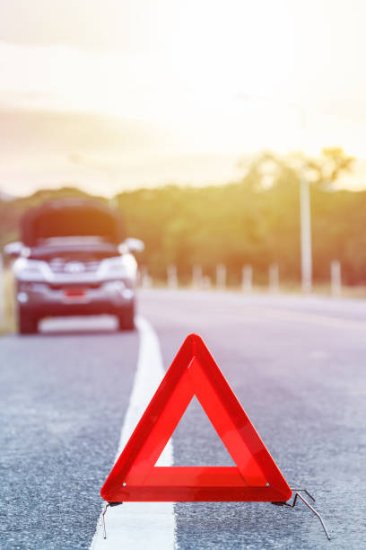istock Red emergency stop sign and broken silver car on the road 673577274