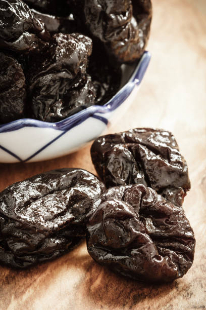 istock dried plums prunes on wooden table 673585466