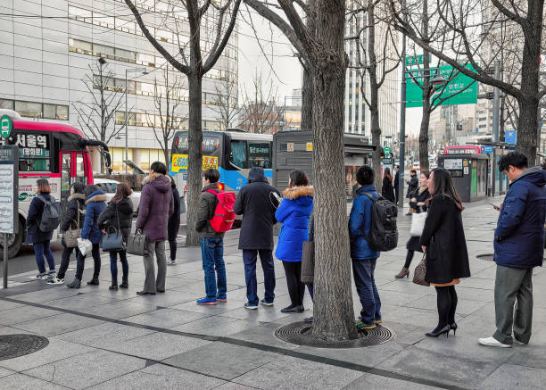 People staying in queue for bus in Jung district Seoul Seoul, South Korea - March 11, 2016: People staying in the queue waiting for the bus in Jung district in Seoul, South Korea seoul bus stock pictures, royalty-free photos & images