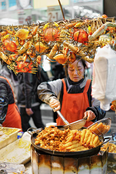 Woman selling seafood in Myeongdong street market in Seoul Seoul, South Korea - March 14, 2016: Woman selling seafood in Myeongdong street market in Seoul, South Korea. Selective focus dong stock pictures, royalty-free photos & images