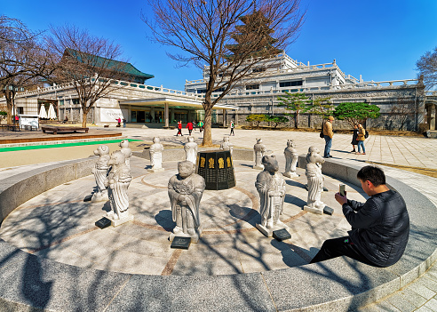Seoul, South Korea - March 11, 2016: Twelve Zodiac animal deities near National Folk Museum of Korea in Gyeongbokgung Palace in Seoul, South Korea. People in the street