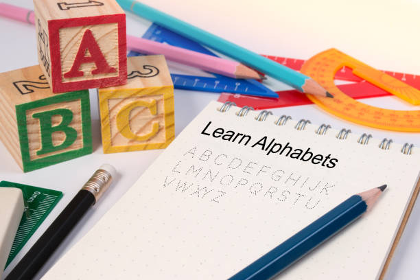 istock Wood letter blocks alphabet ABC with notebook or worksheet for practice alphabet handwriting drill. 673589494