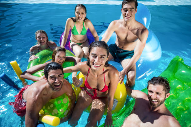 istock Group of friends having fun in swimming pool 673593320