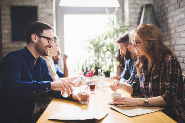 istock Happy colleagues from work socializing in restaurant and eating together 673593976