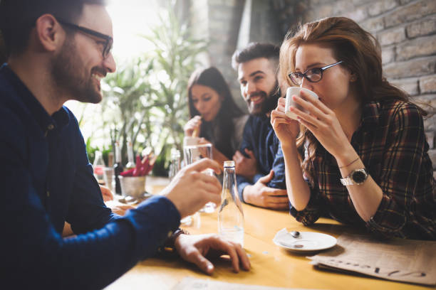 istock Happy colleagues from work socializing in restaurant and eating together 673594112