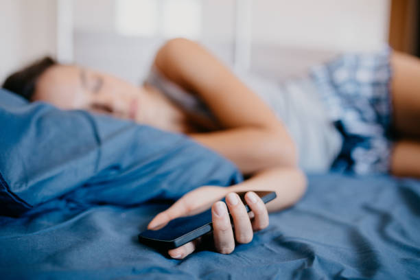 istock Young girl sleeping with phone in her hand 673596312