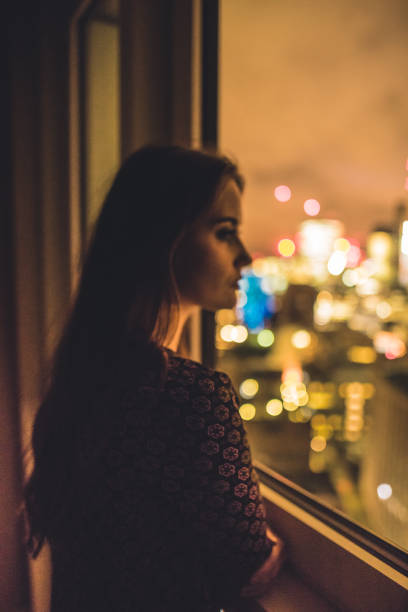 woman looking pensive outside the window