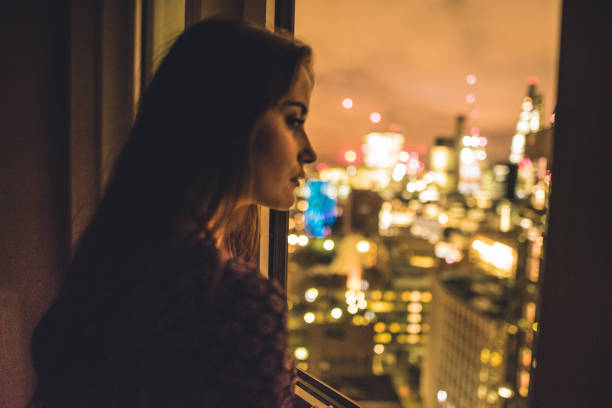 istock woman looking pensive outside the window 673597644