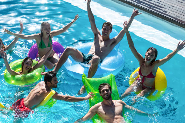 istock Group of friends having fun in swimming pool 673599480