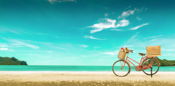 Red vintage bicycle on white sand beach over blue sea and clear blue sky background, spring or summer holiday vacation concept,vintage style.