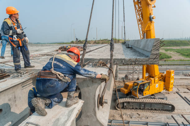 Workers mount bridge span Tyumen, Russia - July 31, 2013: JSC Mostostroy-11. Bridge construction for outcome of the Tobolsk path and Bypass road round Tyumen. Workers mount bridge span western siberia stock pictures, royalty-free photos & images