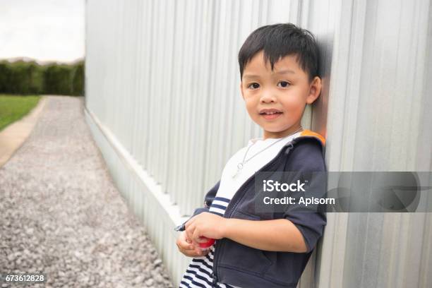 Happy Cute Boy Leaning Wall Of Building And Perspective Way Background Stock Photo - Download Image Now