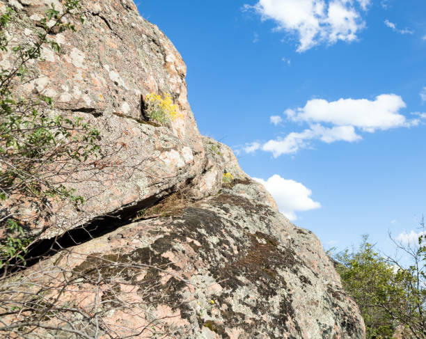 istock Granite rock with a big slit, blue sky on the background 673617228