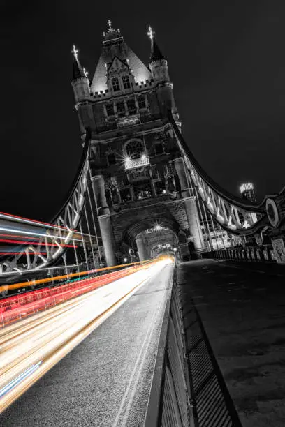 Tower Bridge in London in black and white, UK at night with blur colored car lights. One of the most famous history building in England