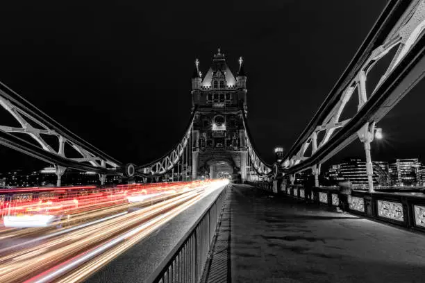 Tower Bridge in London in black and white, UK at night with blur colored car lights. One of the most famous history building in England