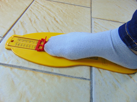 yellow foot measurement device with foot being measured