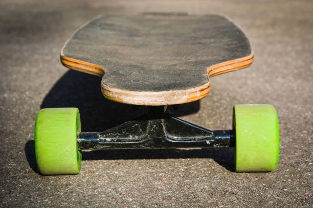 istock Old used longboard on the ground. Black skateboard on an empty asphalt road. Shallow depth of field. Close up. 673663662